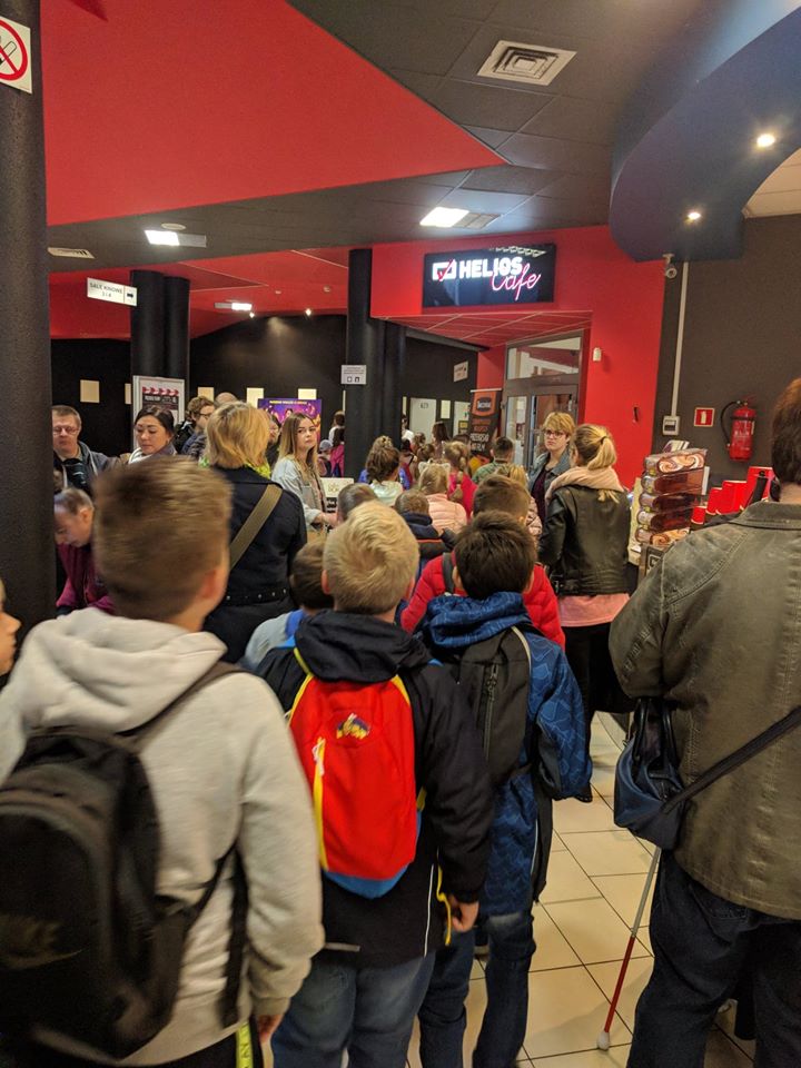 Widzowie czekają na pokaz w kinowym korytarzu.